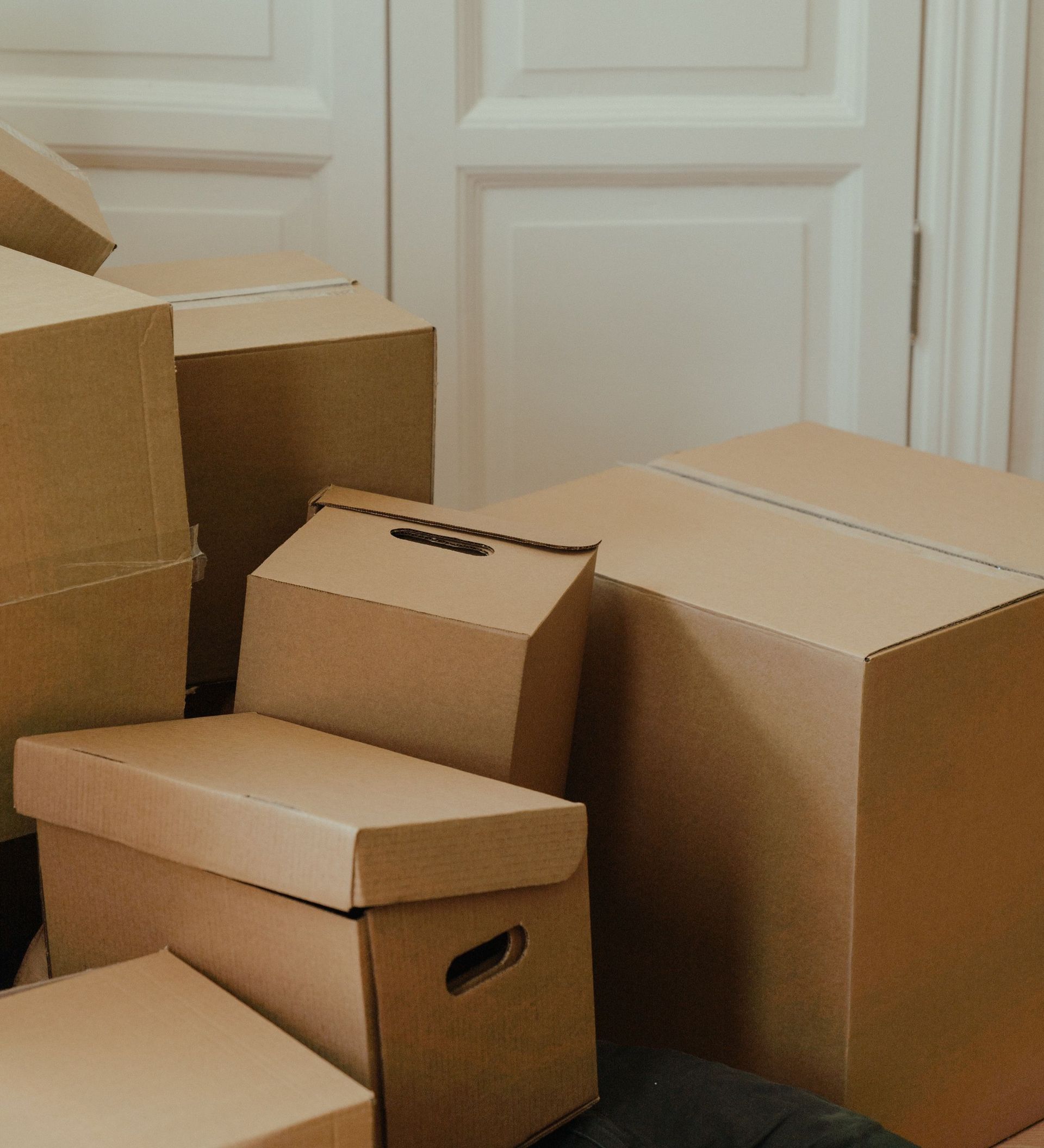 Cardboard boxes stacked in an apartment, signifying a move-in or relocation process.
